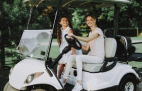 Woman and child riding in customized white golf cart