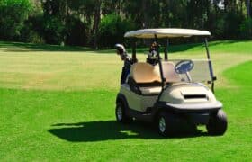 Golf cart on a green golf course, showcasing potential for lithium battery upgrades